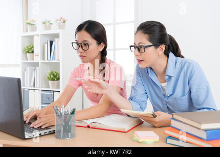 Ernst hübschen weiblichen Studenten nutzen mobile Laptop studieren mit ihrem Hauslehrer und Erforschung der schulischen Bildung Hausaufgaben Antwort durch Onli Stockfoto