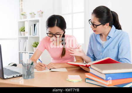 Professionelle pretty Familie Lehrerin Frau spricht Schulbuch englisch Inhalt für Schüler und testen ihr Ergebnis zu studieren. Stockfoto
