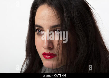 Attraktive junge Frau mit lange blonde Haare das Tragen der roten Lippenstift aus der Seite mit einem ernsten Ausdruck Stockfoto