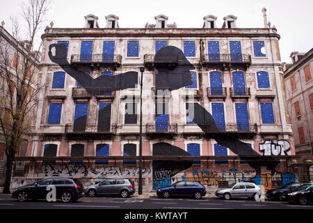 Ein riesiger Mann, den Kopf und die Arme aus dem Fenster eines alten, verlassenen Gebäude. Das Kunstwerk wird durch street artist gemacht Sam 3 Wer ist eine von 16 Künstlern, die an der Crono Projekt in Lissabon stattfand. Portugal 2013. Stockfoto