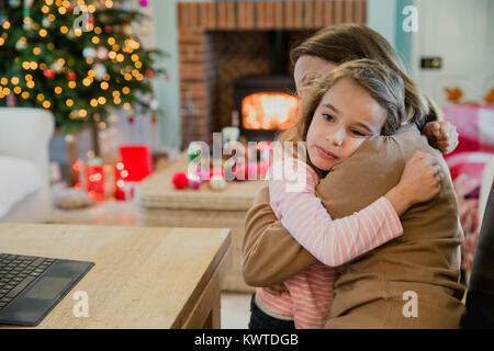 Trauriges kleines Mädchen ist Kuscheln mit ihrer Mutter zu Weihnachten. Stockfoto