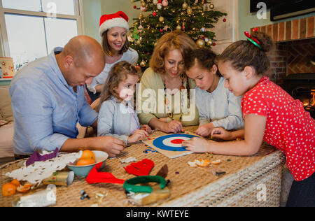 Familie sind Brettspiele zusammen im Wohnzimmer ihres Hauses zur Weihnachtszeit. Stockfoto