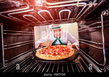 Chefkoch Pizza in den Ofen, Blick aus dem Inneren des Ofens. Kochen in den Ofen. Stockfoto