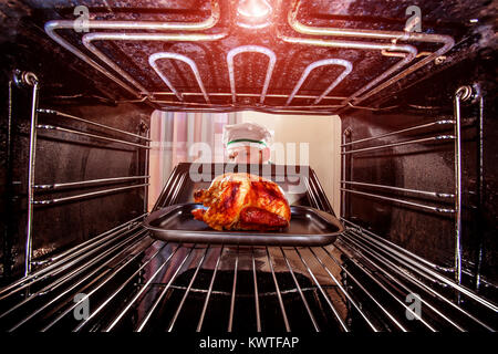 Chefkoch gebratenes Huhn in den Ofen, Blick aus dem Inneren des Ofens. Kochen in den Ofen. Stockfoto