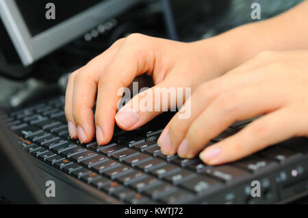 Männliche Hand eingeben und Arbeit Aufgaben auf elegante schwarze Tastatur. Schwerpunkt liegt auf der rechten Seite. Stockfoto
