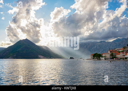 Sonnenstrahlen durch die Wolken in der fjordähnlichen Bucht von Kotor, altes Dorf Perast, Crna Gora, Montenegro, Balkan, Europa Stockfoto