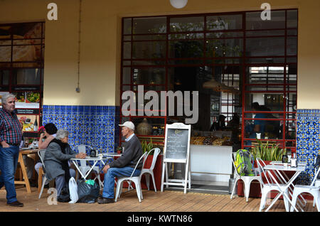 Senior Paar an einem Tisch eines Restaurants im Mercado dos Lavradores, Funchal, Madeira, Portugal sitzt. Stockfoto