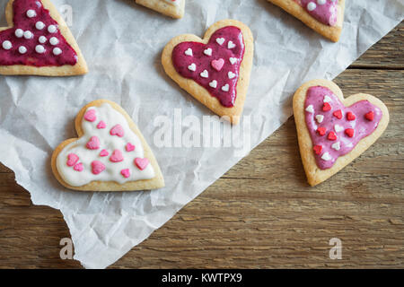 Herzförmige Cookies schließen für Valentinstag - selbstgemachter festlich dekorierten Kuchen Buiscuits Cookies auf Backpapier, Valentinstag Liebe Konzept Stockfoto