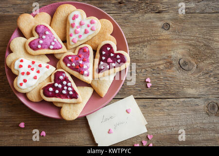 Verglaste Herzform Cookies zum Valentinstag - köstliche hausgemachte natürliche Bio Gebäck, Backen mit Liebe zum Valentinstag, Liebe Konzept Stockfoto