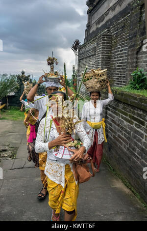 Anbeter mit Angeboten von Blumen und Essen zu Fuß zu den oberen Terrassen von Pura Penataran Agung, Bali, Indonesien Stockfoto