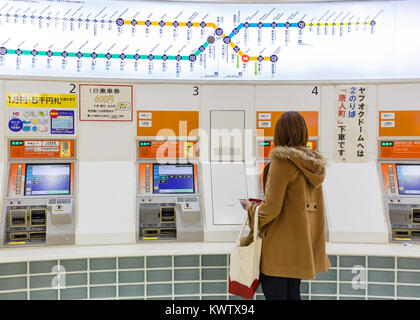 FUKUOKA, Japan - 14. NOVEMBER: Kaufende Fahrkarte in Fukuoka, Japan am 14. November 2013. Unbekannter Menschen Kaufen von Tickets aus dem Automaten bei Haka Stockfoto