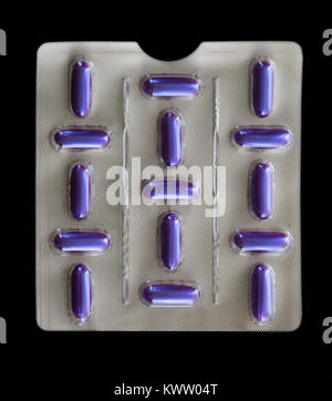 Blisterpackung mit lila Pillen auf schwarzem Hintergrund Stockfoto
