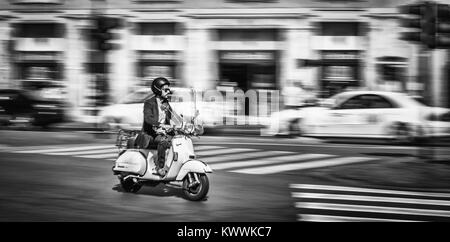 Junger Mann, ein Motorrad in der Stadt von Rom, Italien. In Schwarzweiß und in Bewegung erfasst. Stockfoto