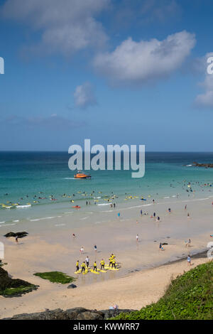 Ein Sommertag am Strand St Ives in Cornwall. Die RNLI lifeboat Patrouillen offshore während Surfers und Touristen die schönen sonnigen Bedingungen genießt. Stockfoto