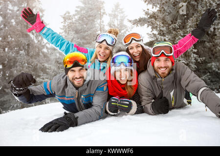 Glückliche junge Freunde auf Skifahren Festlegung gemeinsam auf Schnee Stockfoto