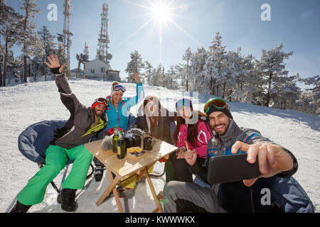 Skifahrer im Cafe im Freien unter selfie mit Handy Stockfoto