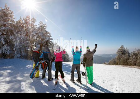 Gruppe von Skifahrern auf Skifahren in Berg mit Skistöcken, Rückansicht Stockfoto