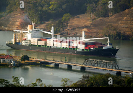 Container schiff durch den Panamakanal, Republik Panama. Im Vordergrund ist das Auto und Eisenbahn Brücke über Rio Chagres bei Gamboa. Stockfoto