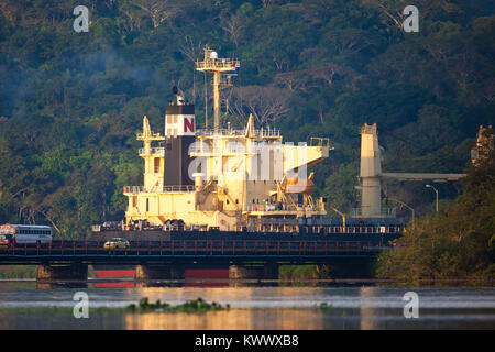 Schiff durch den Panamakanal, Republik Panama. Im Vordergrund steht die Auto- und Eisenbahnbrücke über Rio Chagres bei Gamboa. Stockfoto