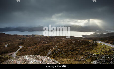 Wellen von Licht durch die Wolken über dem Bereich der Torridon in den schottischen Highlands Stockfoto