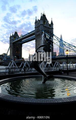 "Das Mädchen mit dem Dolphin' von Sir David Wynne mit Tower Bridge im Hintergrund, London, UK. Stockfoto