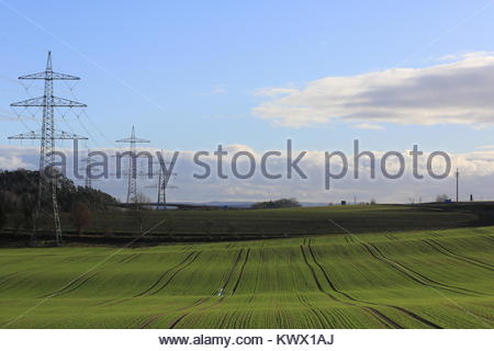 Franken, Deutschland. Sonnenlicht auf frisches Gras wirft Schatten über einem Feld in Deutschland, wo die Masten auch auf der linken Seite gesehen werden kann. Stockfoto