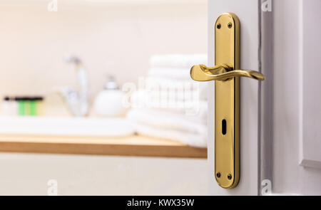 Badezimmer aus offenen Tür. Unscharfer Hintergrund, weiße Handtücher, Seife neben dem Waschbecken. Nahaufnahme, Details. Stockfoto