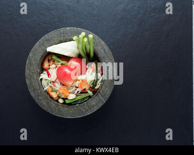 Thai Green Papaya Salat, Som Tam, berühmten Stree essen von Thailand in Granit mörser auf dunklem Hintergrund Stockfoto