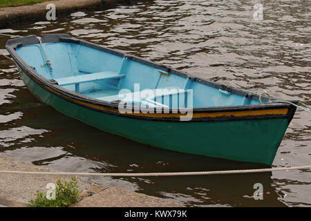 Ein grün und blau Ruderboot gebunden an der Seite eines Flusses. Stockfoto