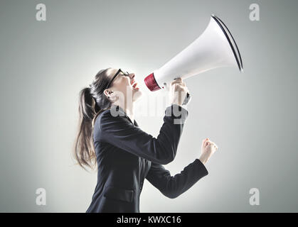 Porträt von eine hübsche Geschäftsfrau, die über das Megaphon schreien Stockfoto