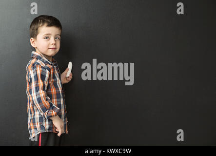 Niedlichen kleinen Jungen an die Tafel zeichnen Stockfoto