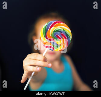 Ingwer-Mädchen hält einen süßen und bunten lollipop Stockfoto