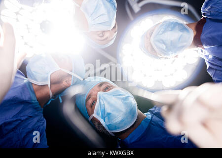 Team von Ärzten, die unter Chirurgie Leuchten in Betrieb Theater. Point of View shot der Chirurgen, die zahnärztliche Chirurgie im Krankenhaus. Stockfoto