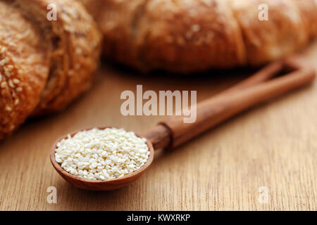 Geschälte Sesamsamen in einem Löffel mit nahrhaftem Brot Stockfoto