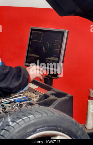 Mechaniker arbeiten an Auswuchtmaschine in der garage Stockfoto