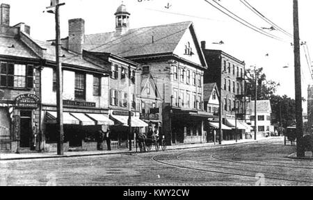 Ein historisches Bild des Medford Square und seines Bahnhofs aus den frühen 1900er Jahren, das städtebauliche Entwicklung, Transport und architektonische Merkmale der Epoche in Medford, Massachusetts, veranschaulicht. Stockfoto
