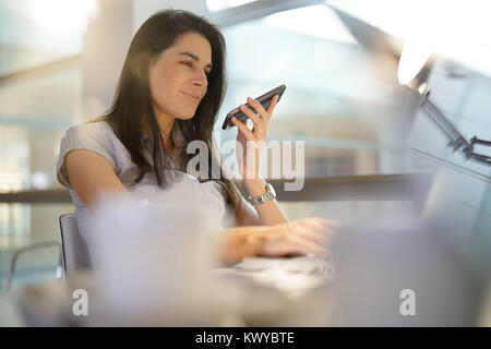 Geschäftsfrau im Büro mit smartphone Stockfoto
