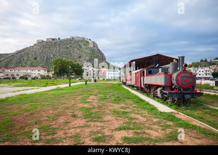 Alte Zug am Bahnhof in Nafplio und die Festung Palamidi auf dem Berg in Nafplion, Griechenland Stockfoto