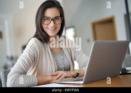 Portrait von lächelnden aktive Frau mittleren Alters, die von zu Hause aus arbeiten Stockfoto