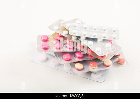 Stapel von bunten Pillen auf weißem Hintergrund Stockfoto