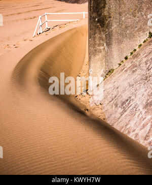 Wind-driven sand Bildung vor einem Meer Wand an der Aberavon Beach, South Wales, UK. Stockfoto