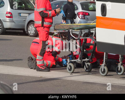 Sanitäter rettete ein Kerl, der ein Motorrad Unfall mit seinem Motorrad hatte, vor dem Laden auf dem Krankenwagen Stockfoto