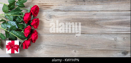Halbes Dutzend rote Rosen und Geschenk Box auf der linken Seite des rustikalen, mit Holz in Flach anzeigen Stockfoto