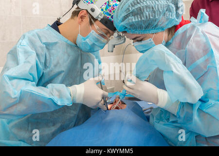 Gesundheitswesen, Medizin. Patienten mit Zahnarzt in Maske mit Lupe Fernglas in einer Zahnarztpraxis. Stockfoto