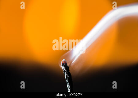Rauch aus gelöscht wick Orange verschwommenen Hintergrund. Stockfoto