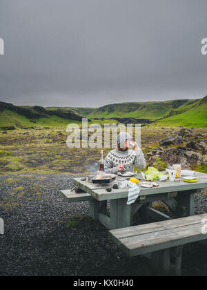 Mädchen in einem traditionellen isländischen Pullover bei einem Picknick mit einem malerischen Blick auf einem Hintergrund Stockfoto