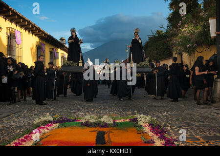 Antigua, Guatemala - 19. April 2014: Menschen in schwarzen Roben in einer Straße der alten Stadt Antigua während einer Prozession der Heiligen Woche in Antigua Stockfoto