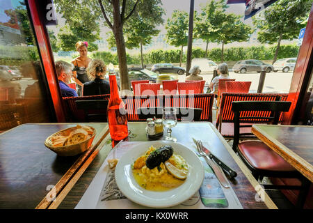 Frankreich, Paris, Mittagessen in einem Bistro mit Blick durch ein offenes Fenster auf die Bäume und die Terrasse des Restaurants Stockfoto