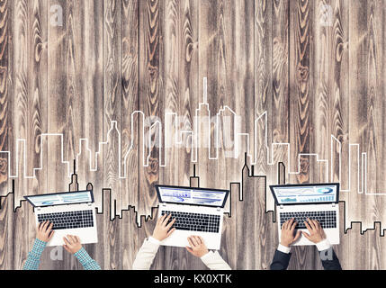 Gruppe von drei Personen mit Geräten in Händen arbeiten zusammen als Symbol der Vernetzung und Kommunikation Stockfoto