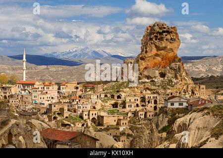 Blick über die Stadt von Ortahisar und Höhlenwohnungen mit Mount Erciyes in den Hintergrund, die in Kappadokien, Türkei. Stockfoto